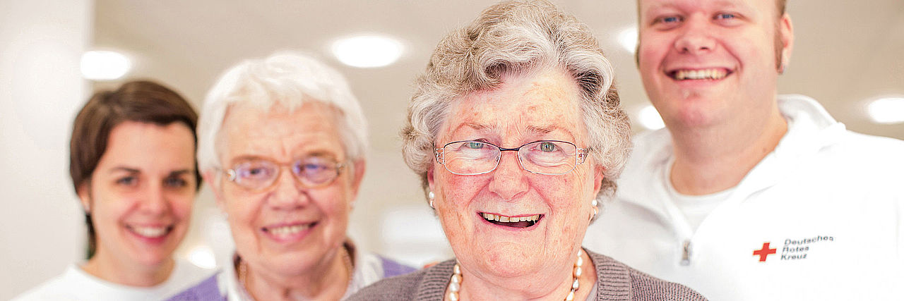 Zwei ältere Damen mit zwei Mitarbeitern des DRK