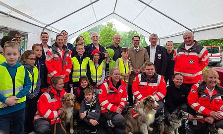 Gruppenfoto nach der Fackelübergabe, viele Ehrenamtliche, Rettungshunde und offizielle Vertreter aus DRK und Politik sind zu sehen.